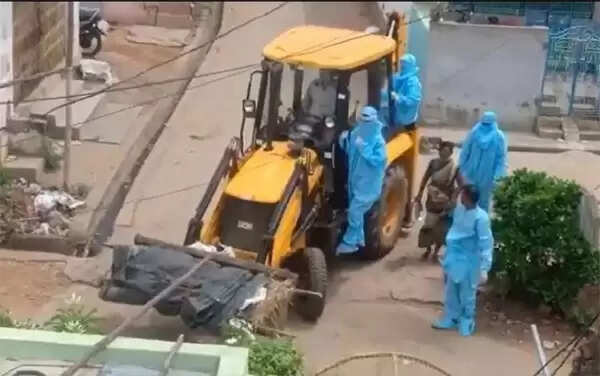 കോവിഡ് ബാധിച്ച് മരിച്ചയാളുടെ മൃതദേഹം കൊണ്ട് പോയത് മണ്ണുമാന്തി യന്ത്രത്തില്; സംഭവം പുറത്തായതോടെ രണ്ട് പേര്ക്ക് സസ്പെന്ഷന്