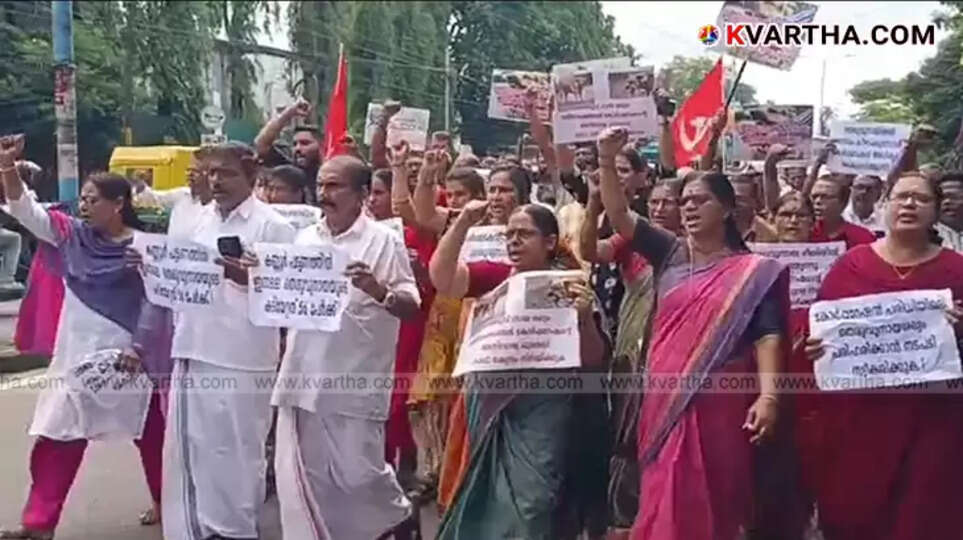 Protesters holding placards and flags outside Kannur Corporation office concerning the street dog menace.