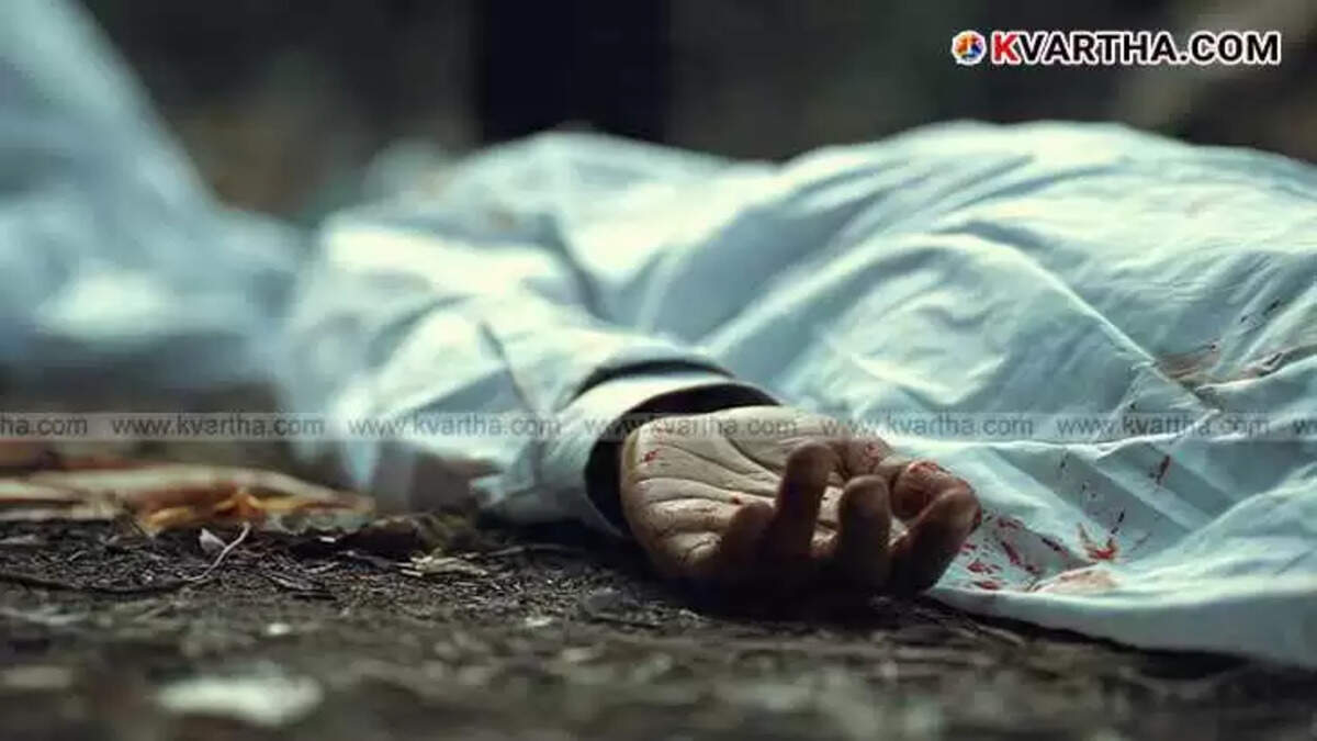 A covered body lies on the ground with a hand visible at a crime scene.