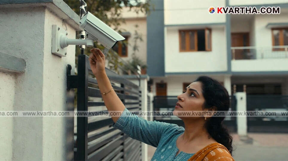A CCTV camera lens overlooking a residential building window, indicating privacy risk.