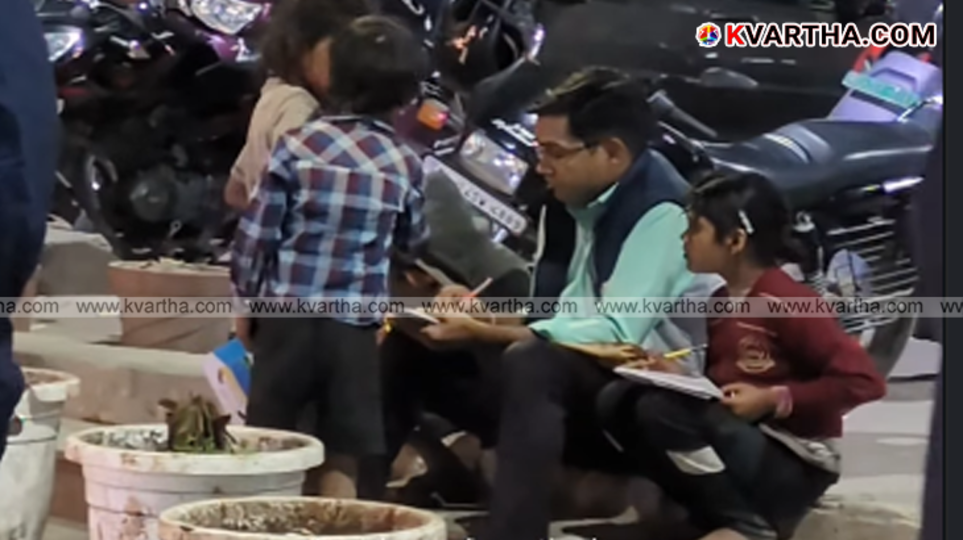 Teacher Krishan Kumar teaching street children on a pavement in Delhi.