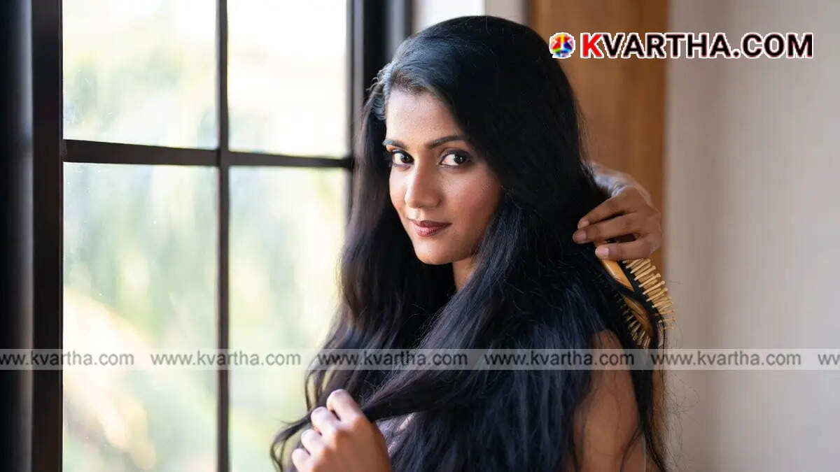 Woman carefully brushing her hair with a wooden comb