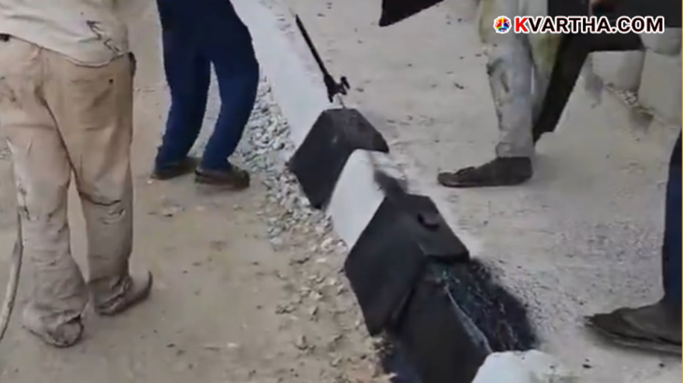 A scene of Indian workers spray painting stones along the roadside.&nbsp;