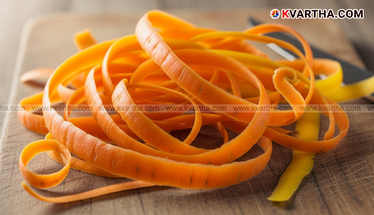 A pile of fresh carrot peels on a cutting board.