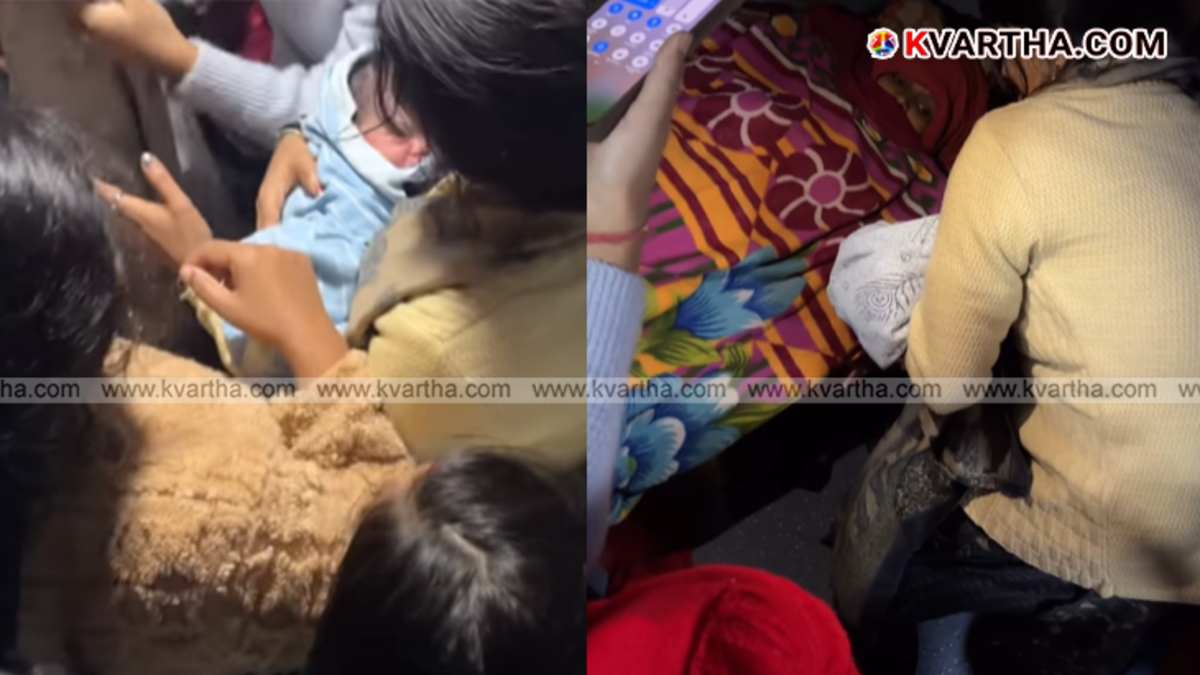 A woman holding a newborn baby wrapped in cloth inside a moving train.