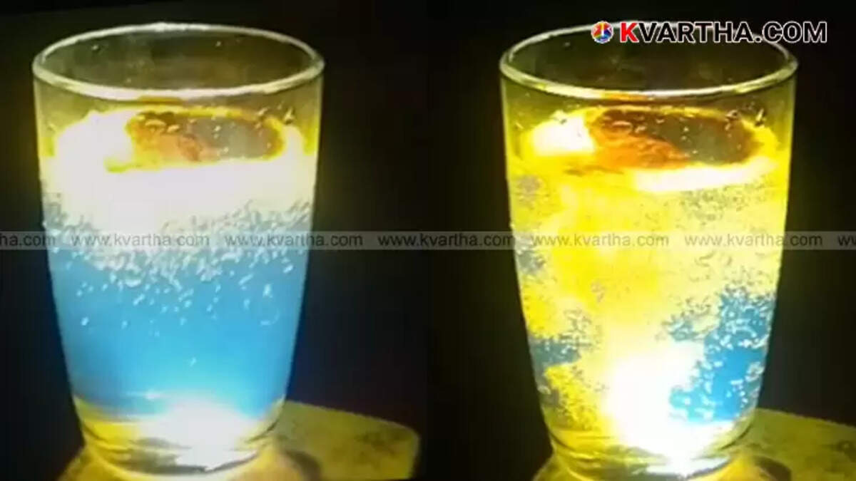A glass of turmeric water with a spoon of turmeric powder.