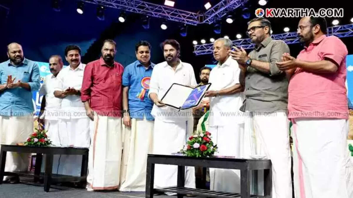 Actor Mammootty receiving the extreme poverty eradication report from CM Pinarayi Vijayan on stage.