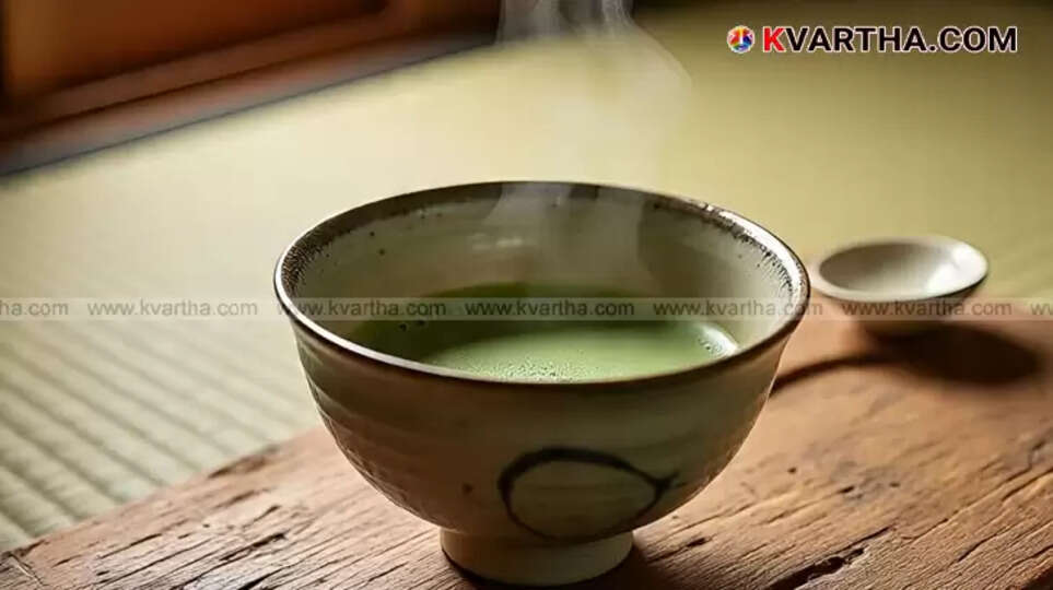 A cup of bright green matcha tea with a bamboo whisk.