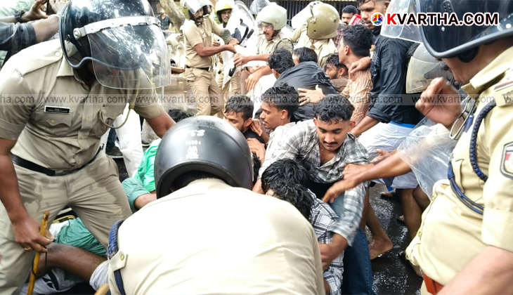 KSU activists protesting against police, being hit by water cannon.