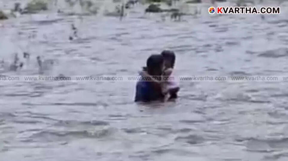 Youth rescuing a child from the strong current of Kottiyoor river.