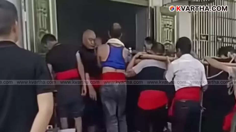  A procession in China with a living elderly woman inside a coffin carried by people.