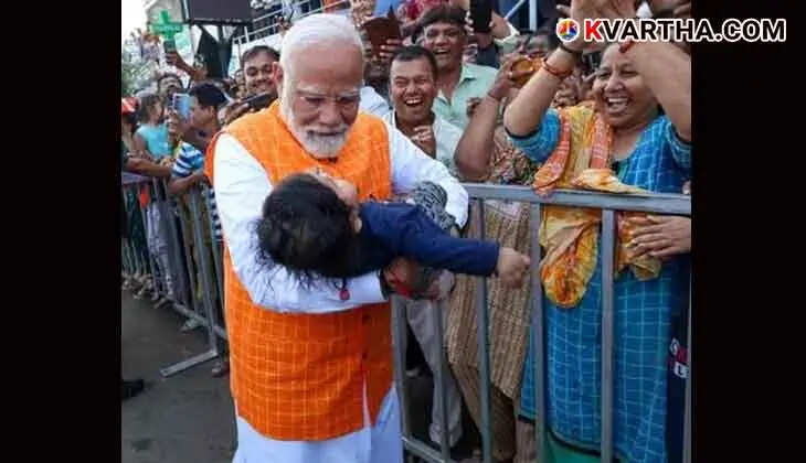 PM Modi cradles a baby in his arms after casting his vote in Ahmedabad