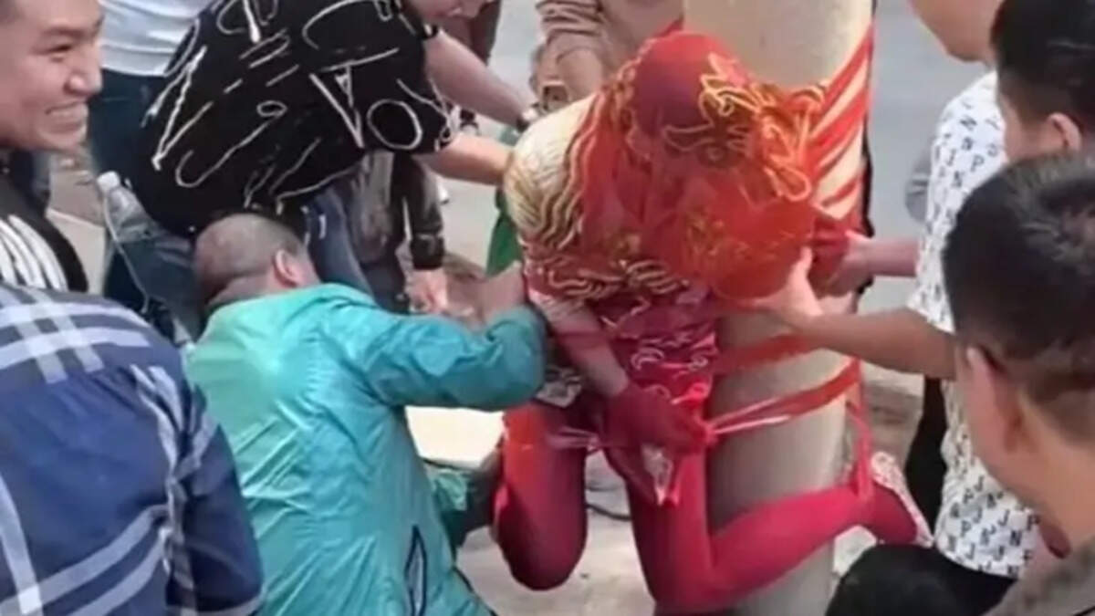 A bride tied to a pole during a Chinese wedding ceremony.