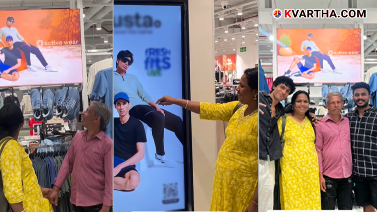  Parents looking at their son Adarsh featured on a large advertisement board inside a mall
