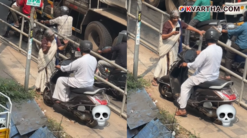An elderly woman standing in front of a scooter on a sidewalk in Kozhikode to prevent it from passing.