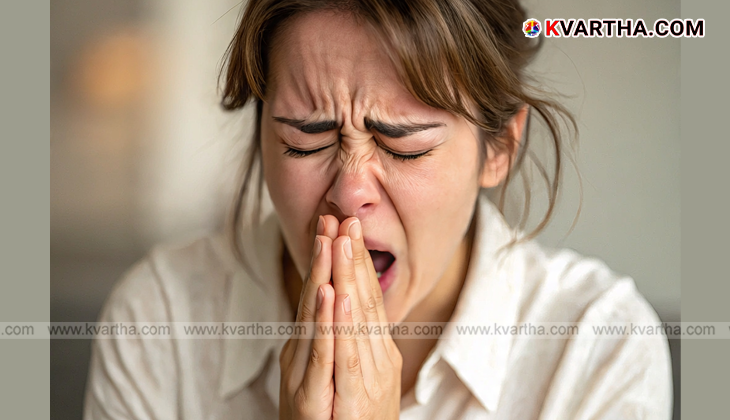 Person holding head with blurred screen background