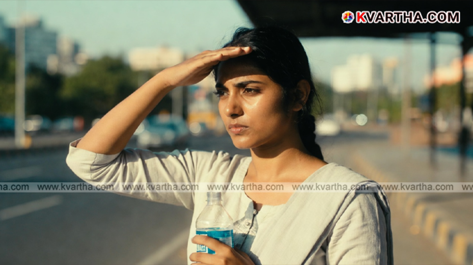 People using umbrellas and drinking water to protect themselves from the intense summer heat in Kerala.
