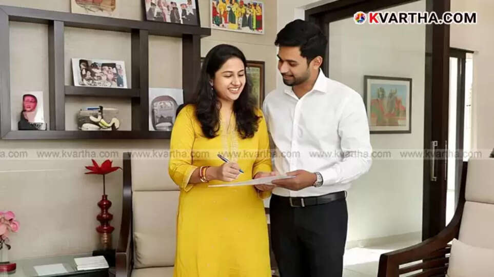 A couple smiling while looking at a house model, representing the financial benefits of registering property in the wife's name. 