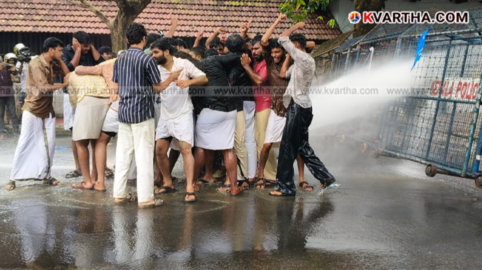 KSU activists protesting against police, being hit by water cannon.