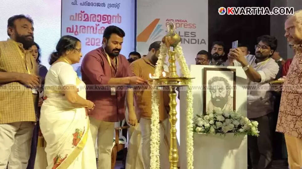  Actor Mohanlal on stage speaking at an awards ceremony, holding a microphone.