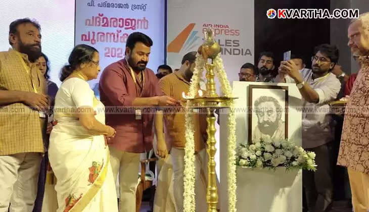 Actor Mohanlal on stage speaking at an awards ceremony, holding a microphone.