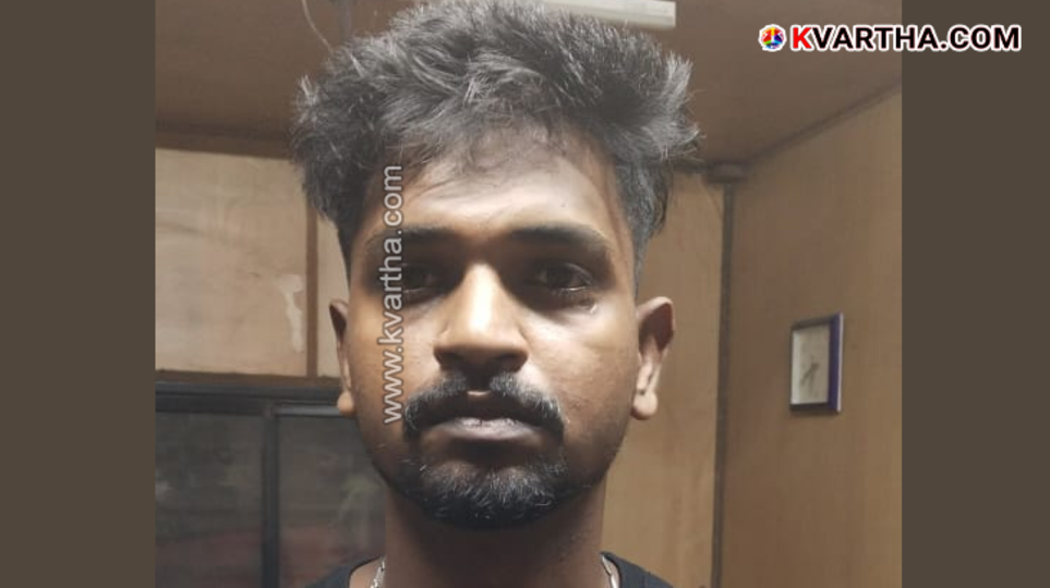 Excise officer holding a packet of hashish oil near a checkpost.