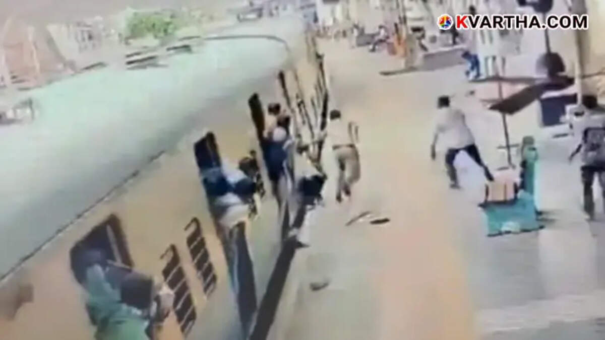 RPF officer rescuing an elderly man from falling under a train.
