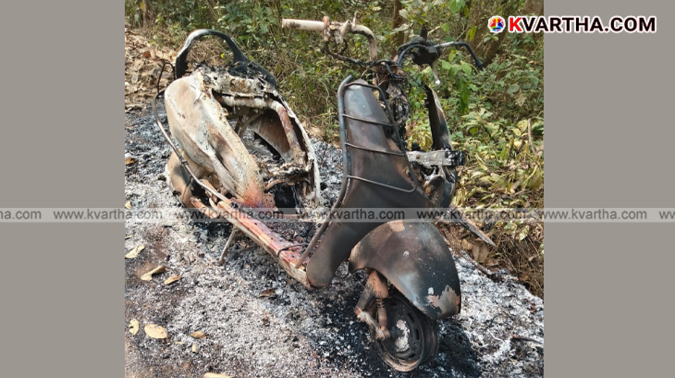 A conceptual image of a burnt scooter parked outside a house.