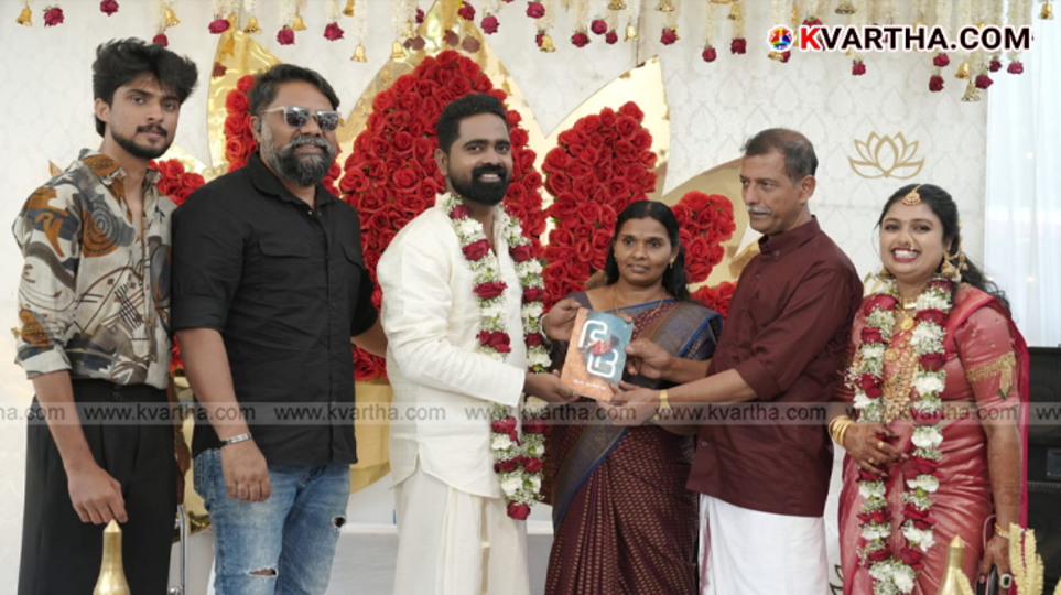 Chef Nalan releasing the book 'Bhadra' by handing it to groom Satheesh at Jimna Karthika's wedding.
