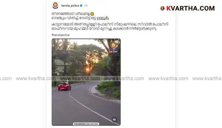 Policeman helping elephant cross the road in Athirapilly.