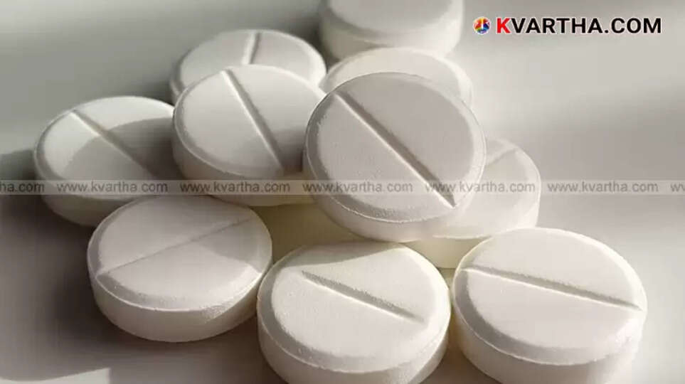 A paracetamol tablet broken in half, showing a metal piece embedded inside it.